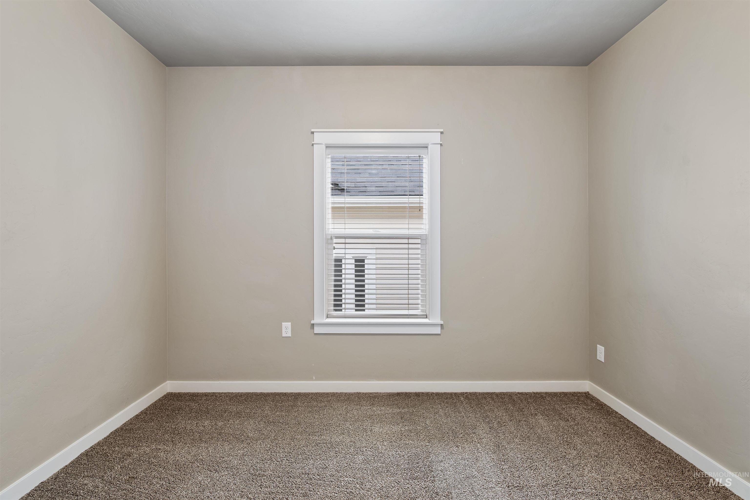 Empty room featuring carpet and baseboards
