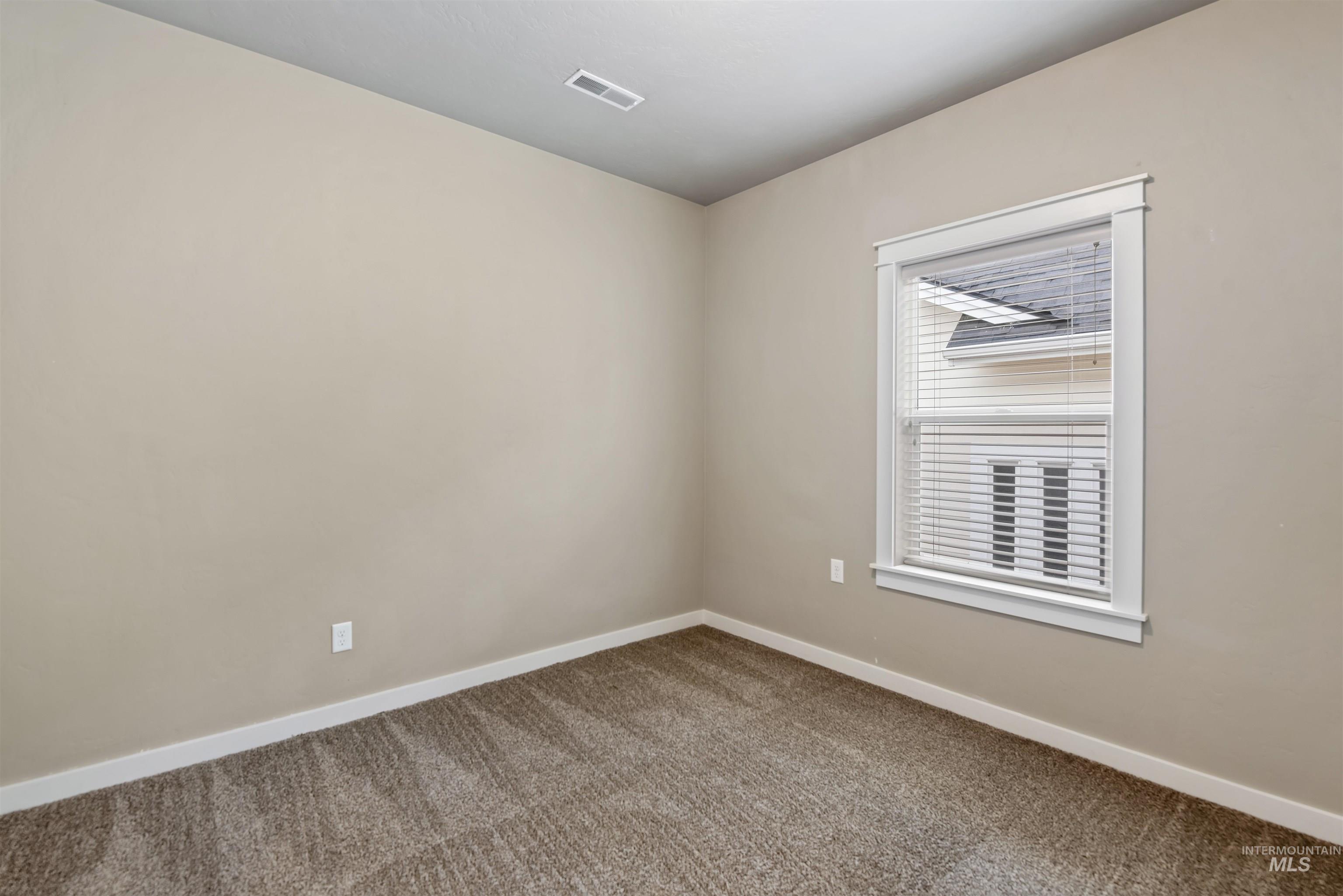 Carpeted empty room featuring baseboards