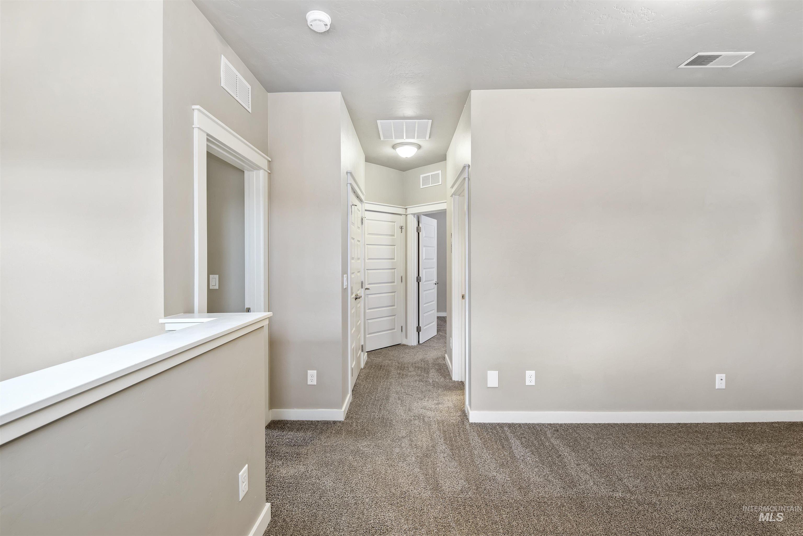 Hall with dark carpet and baseboards
