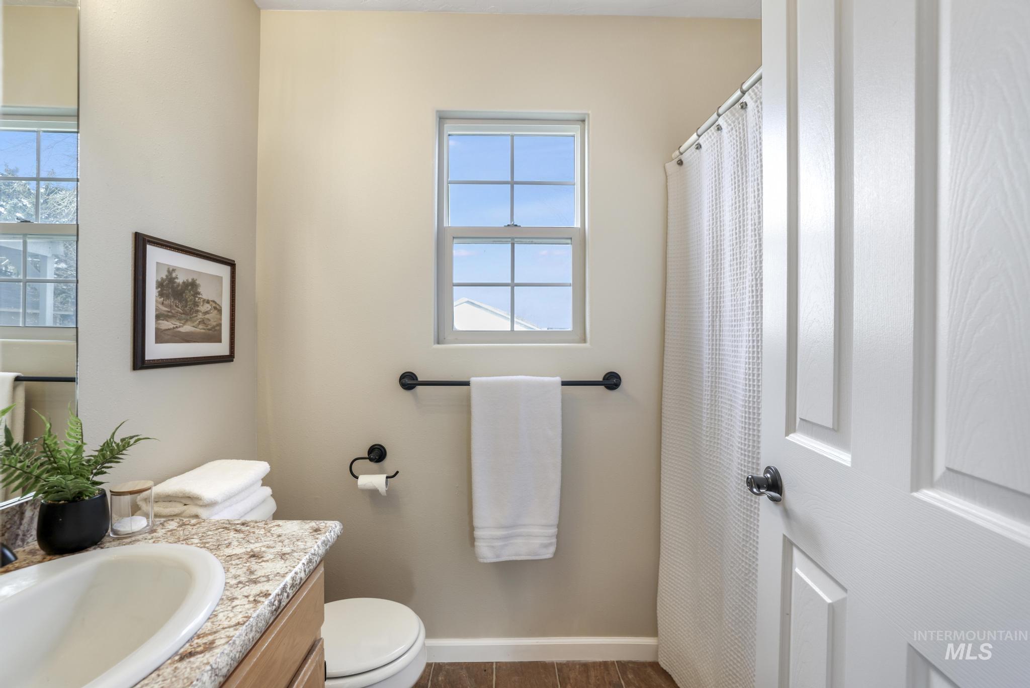 Full bath featuring curtained shower and vanity