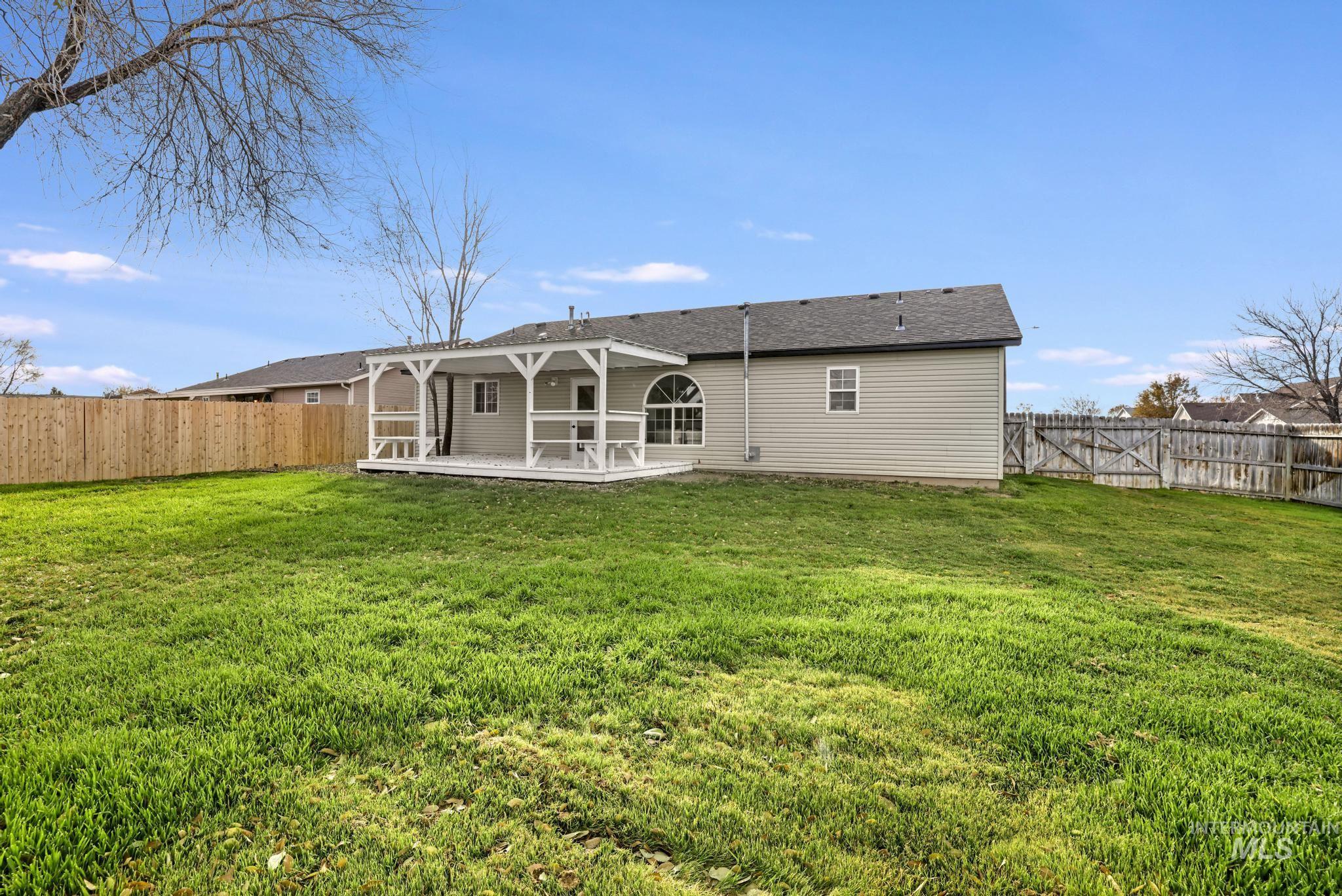 Rear view of house featuring a fenced backyard, a patio, and roof with shingles