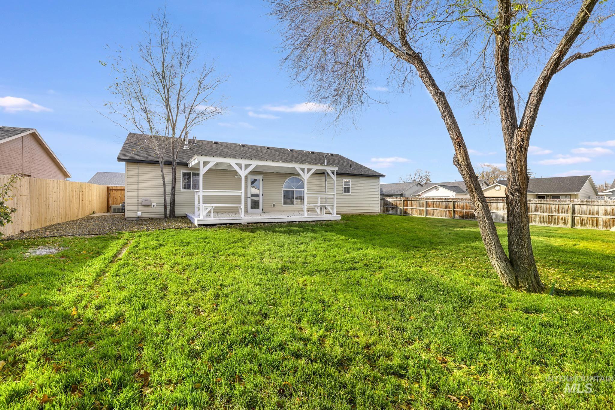 Rear view of property with a fenced backyard and a shingled roof