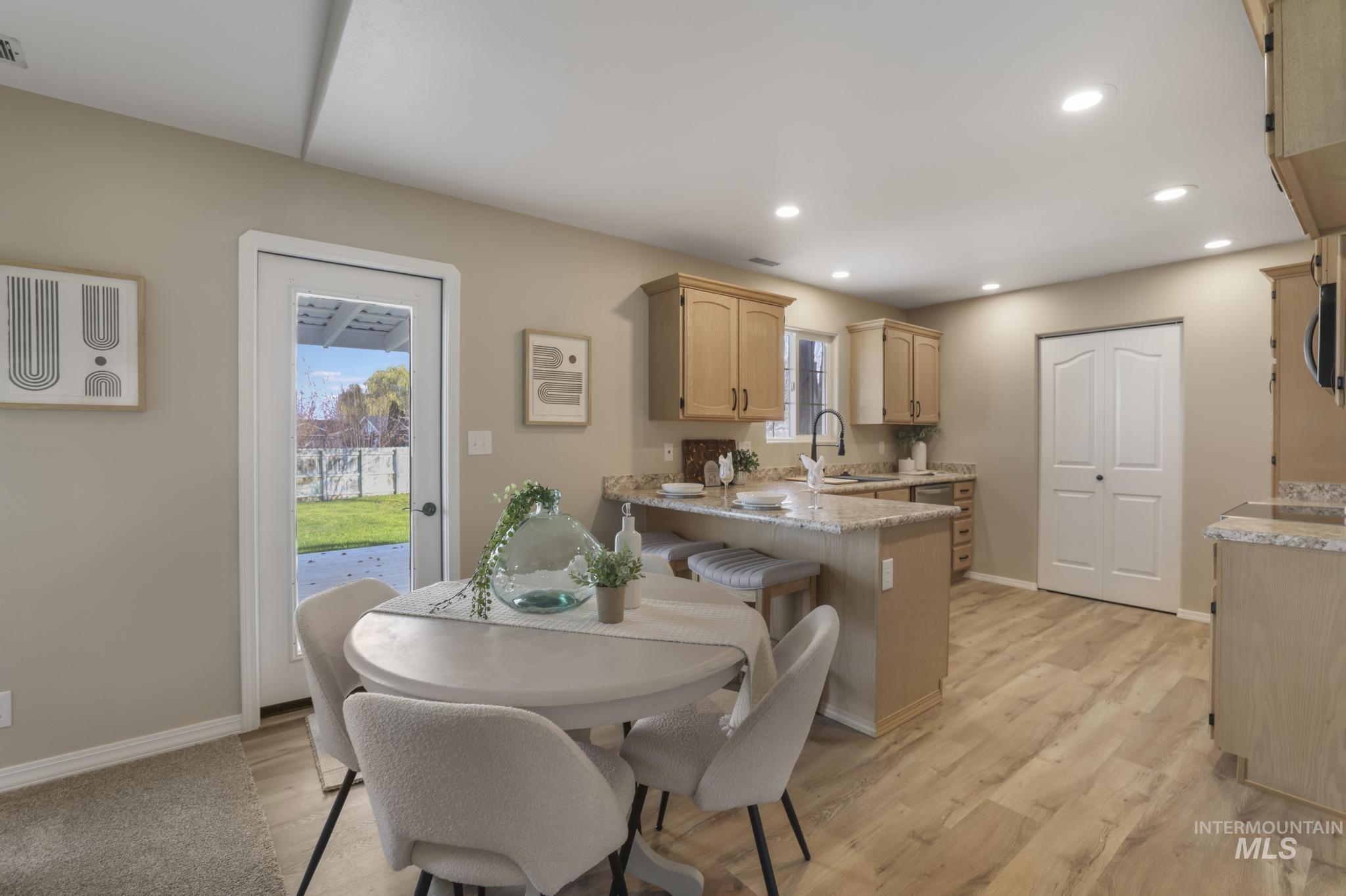 Dining room featuring light wood finished floors, recessed lighting, and a wall mounted AC