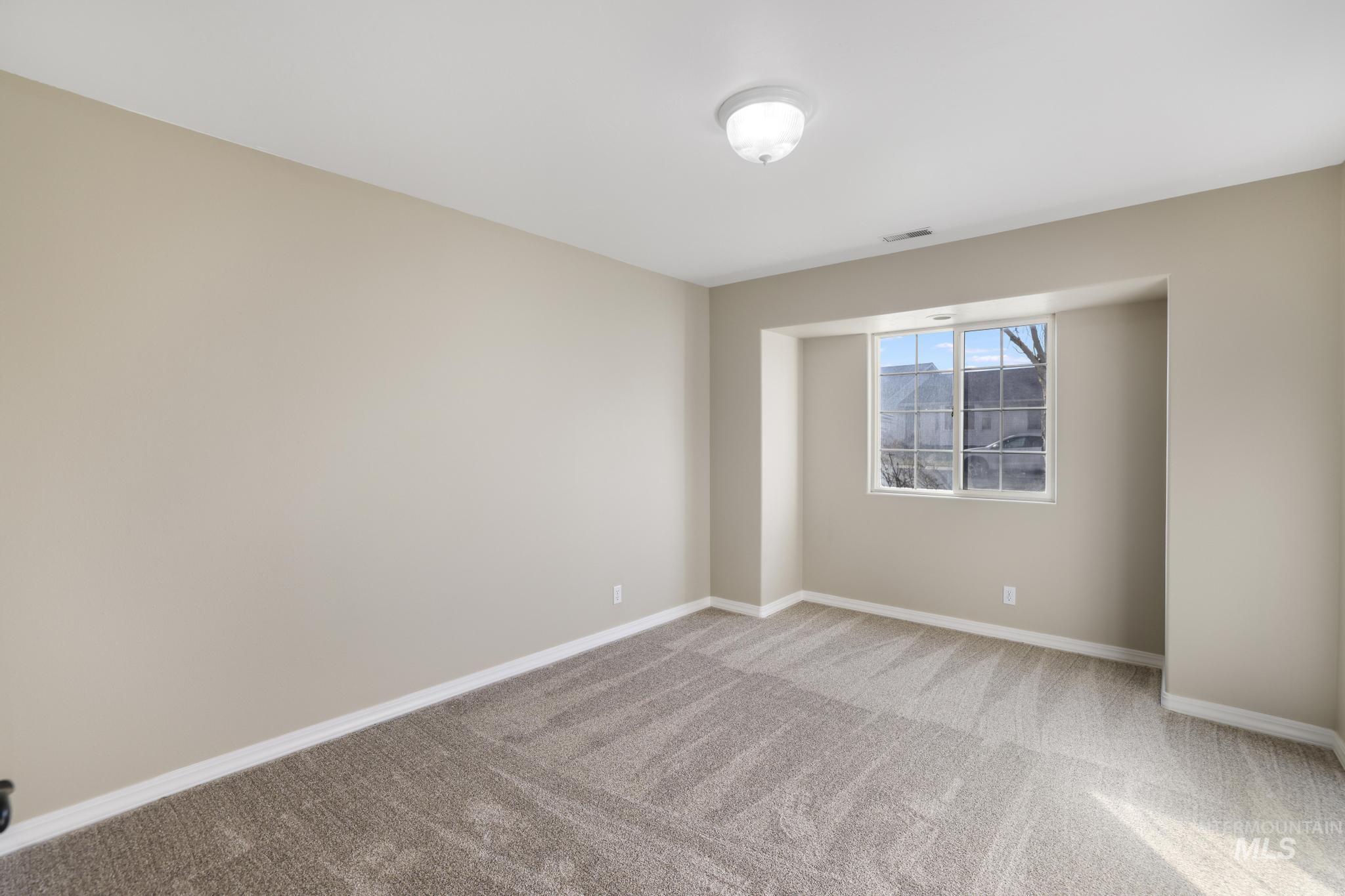 Unfurnished room with light colored carpet and baseboards