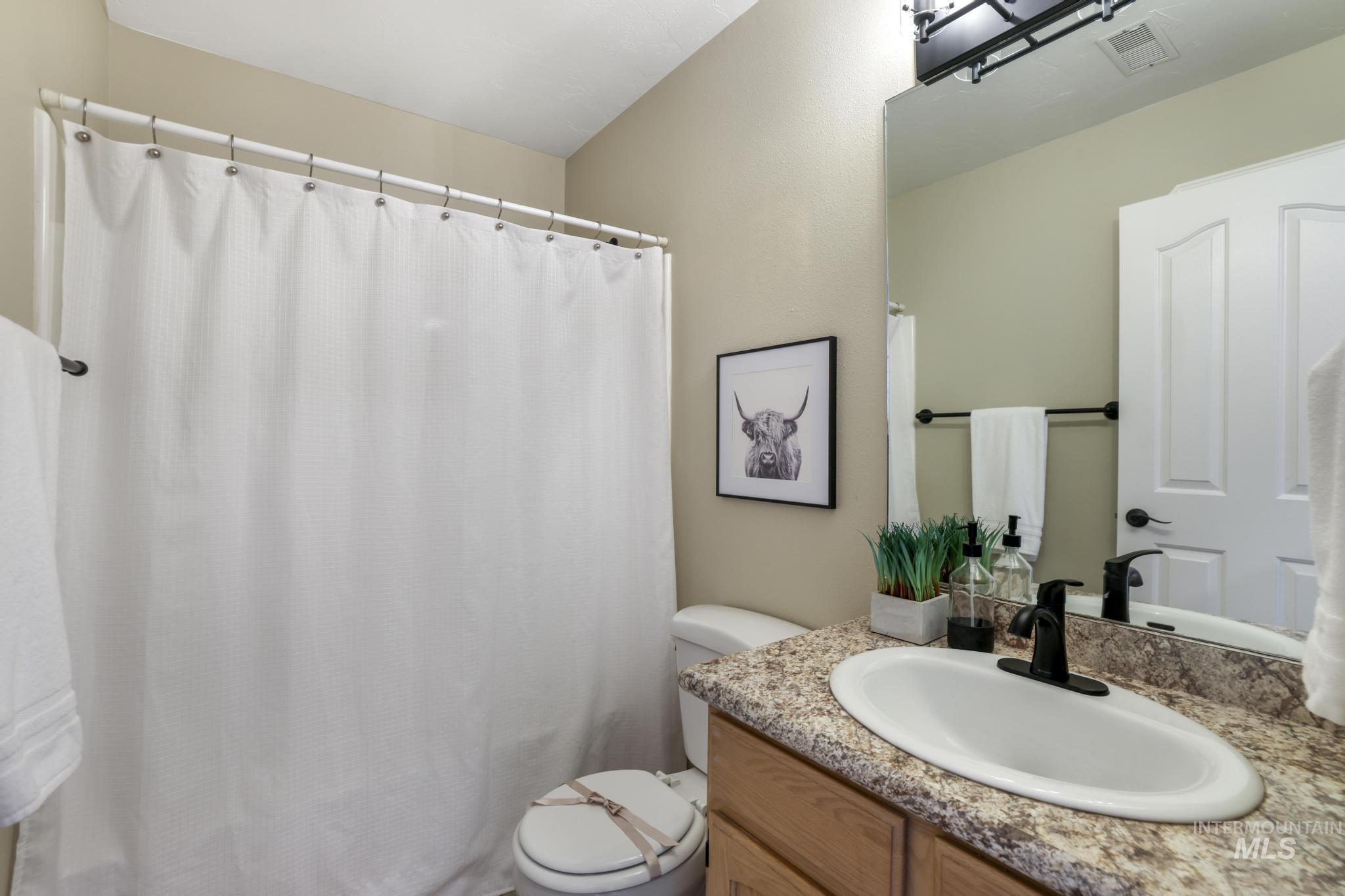 Bathroom featuring vanity and curtained shower