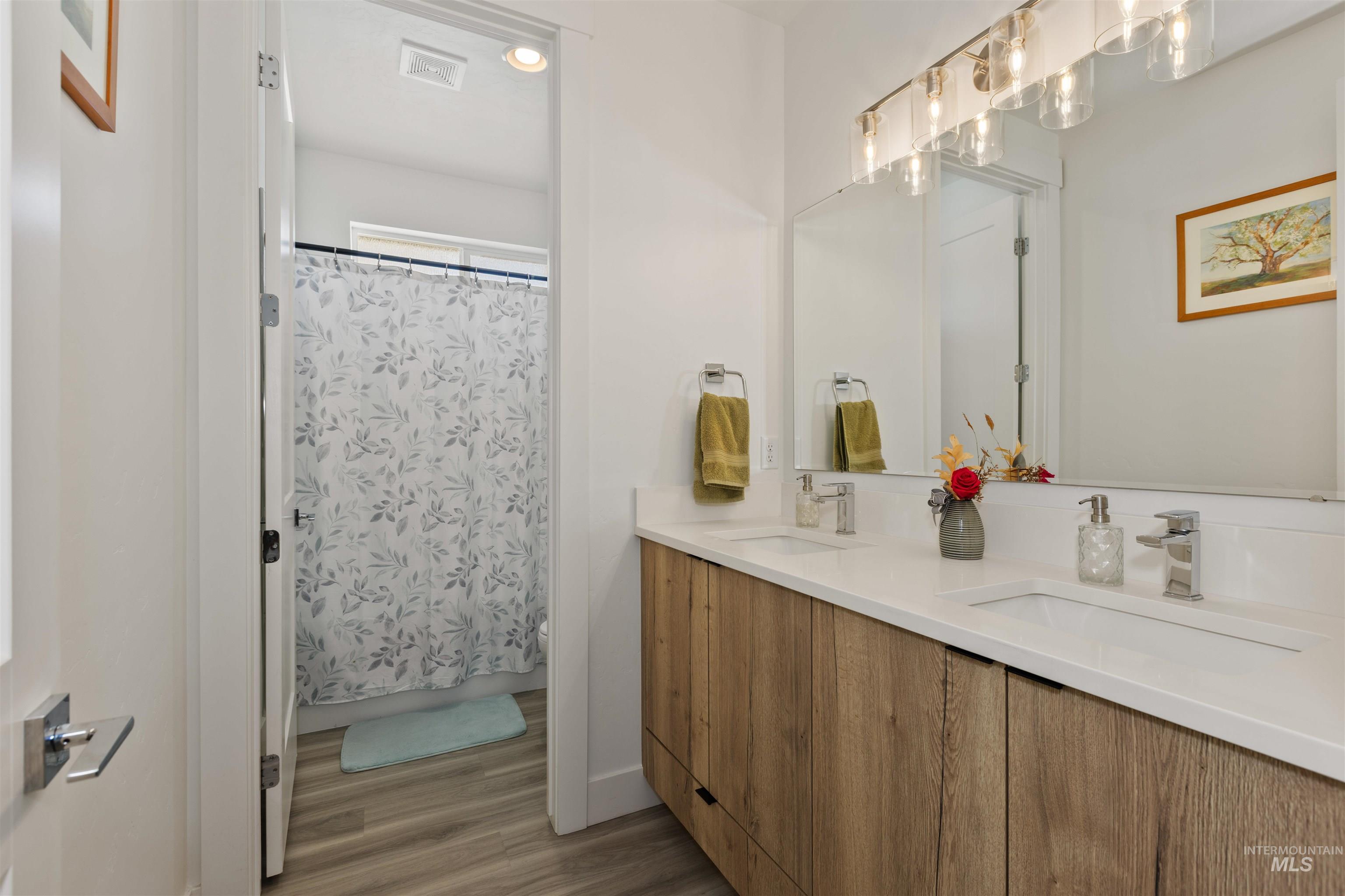 Full bathroom with dual vanity, shower/tub combo