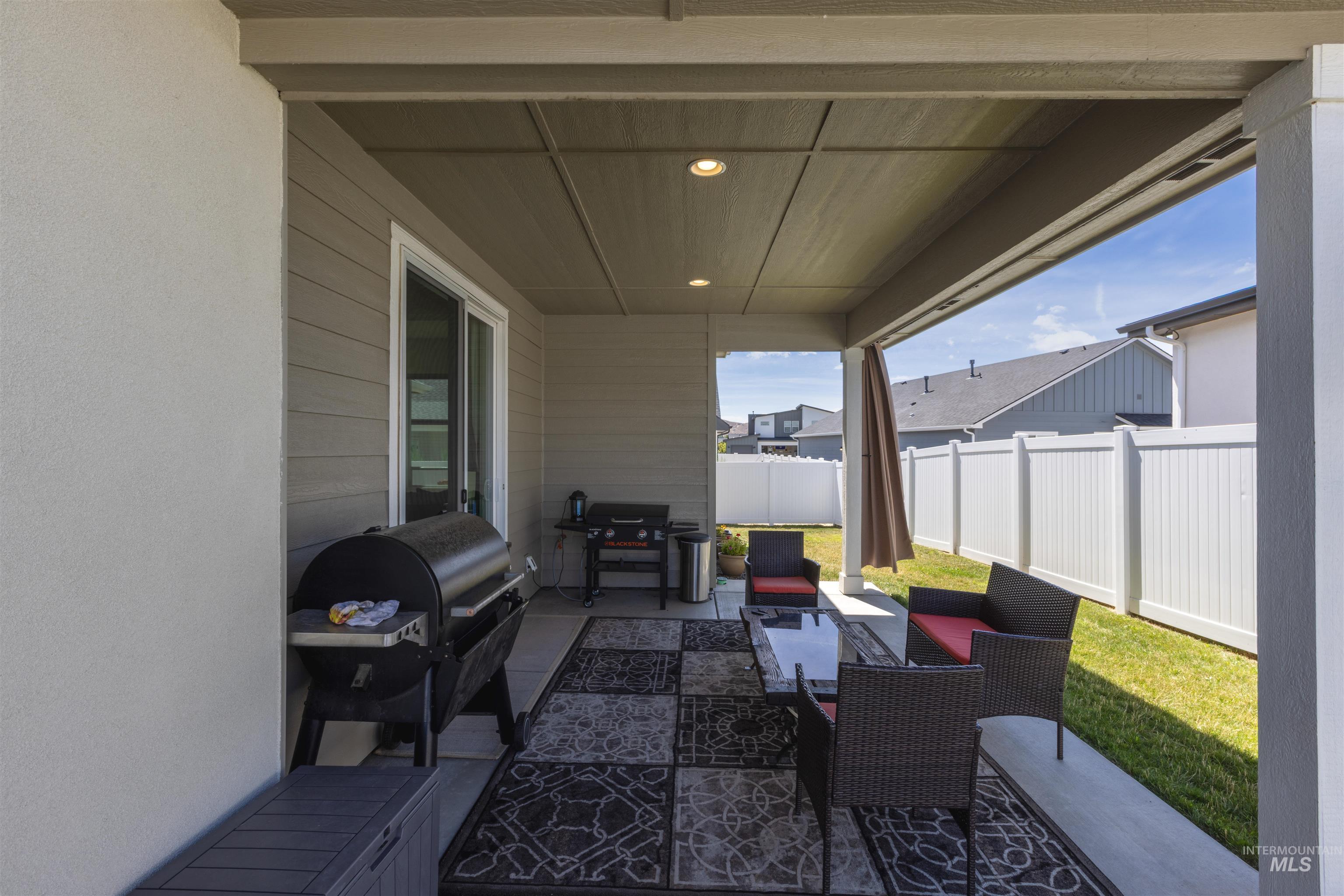 Fenced backyard featuring outdoor lounge area, a patio, and grilling area