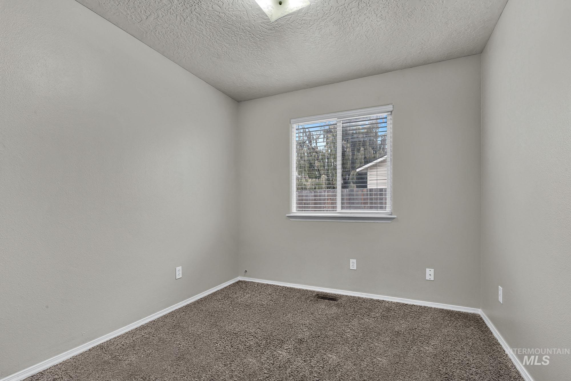 Spare room with carpet flooring and a textured ceiling