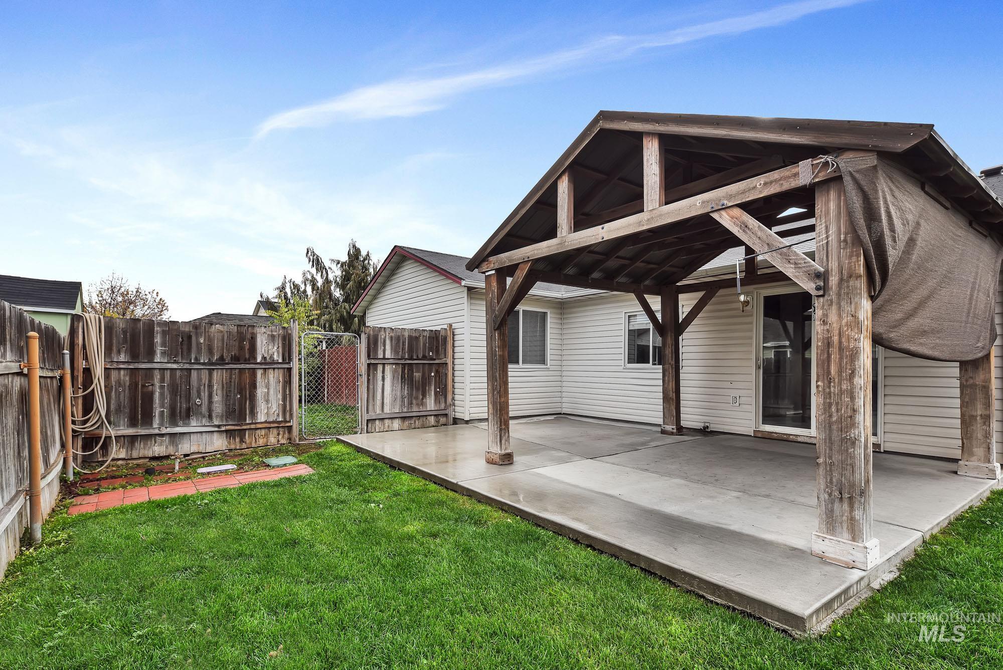 Back of house with a gate and a patio area