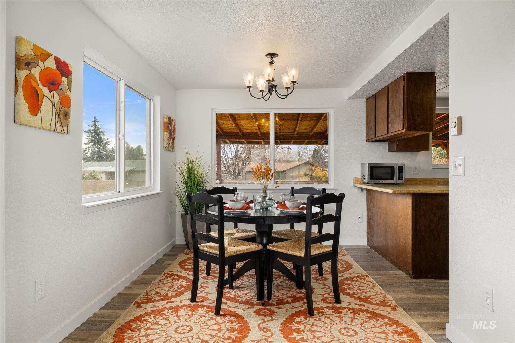 Dining room featuring a chandelier and dark wood-style flooring