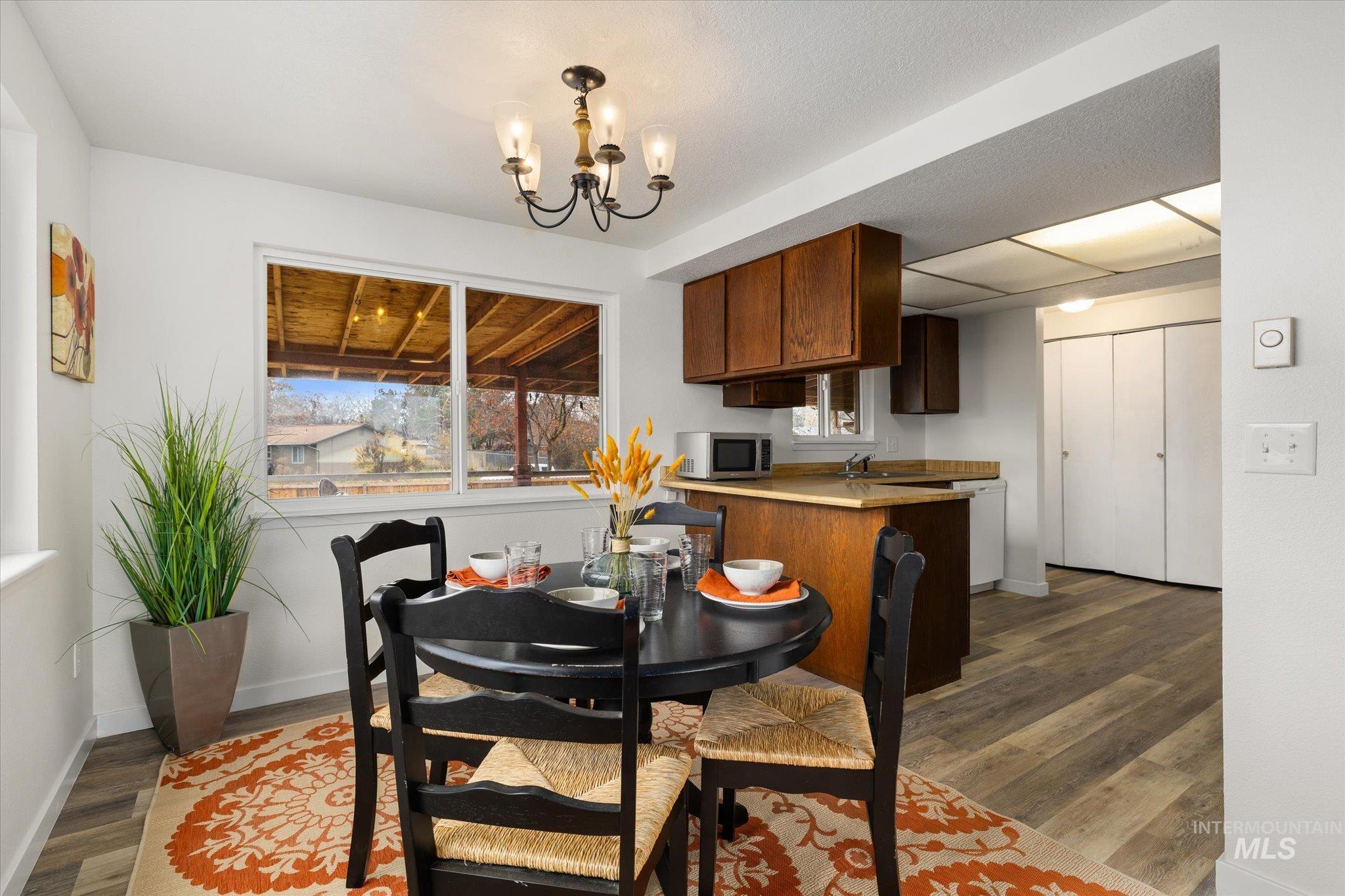 Dining area featuring a chandelier and dark wood-type flooring