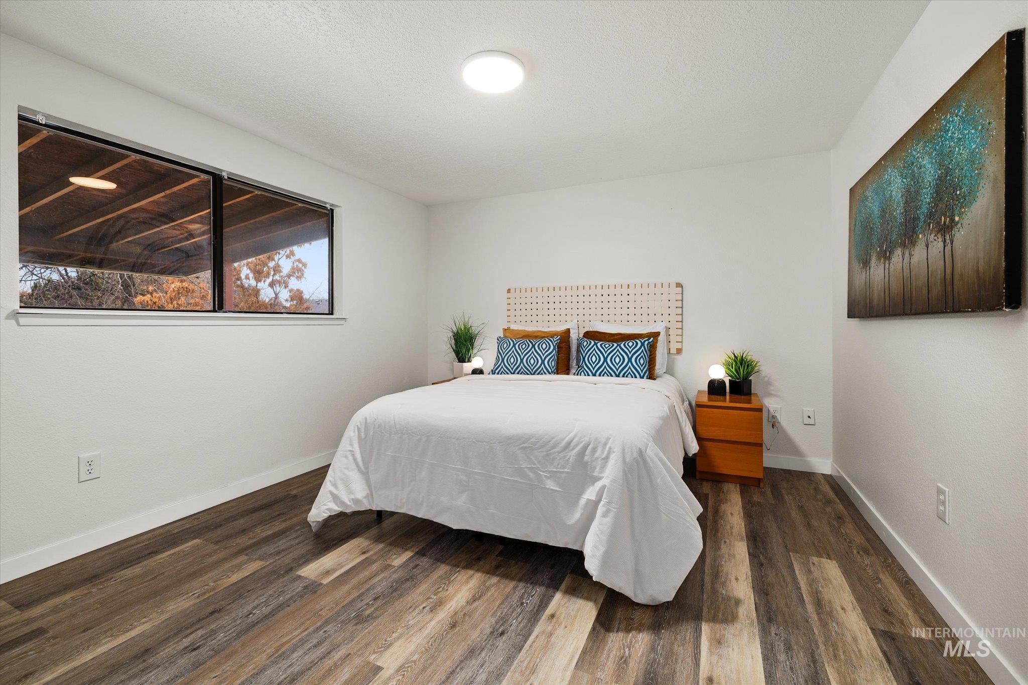 Bedroom featuring dark wood-style flooring and a textured ceiling