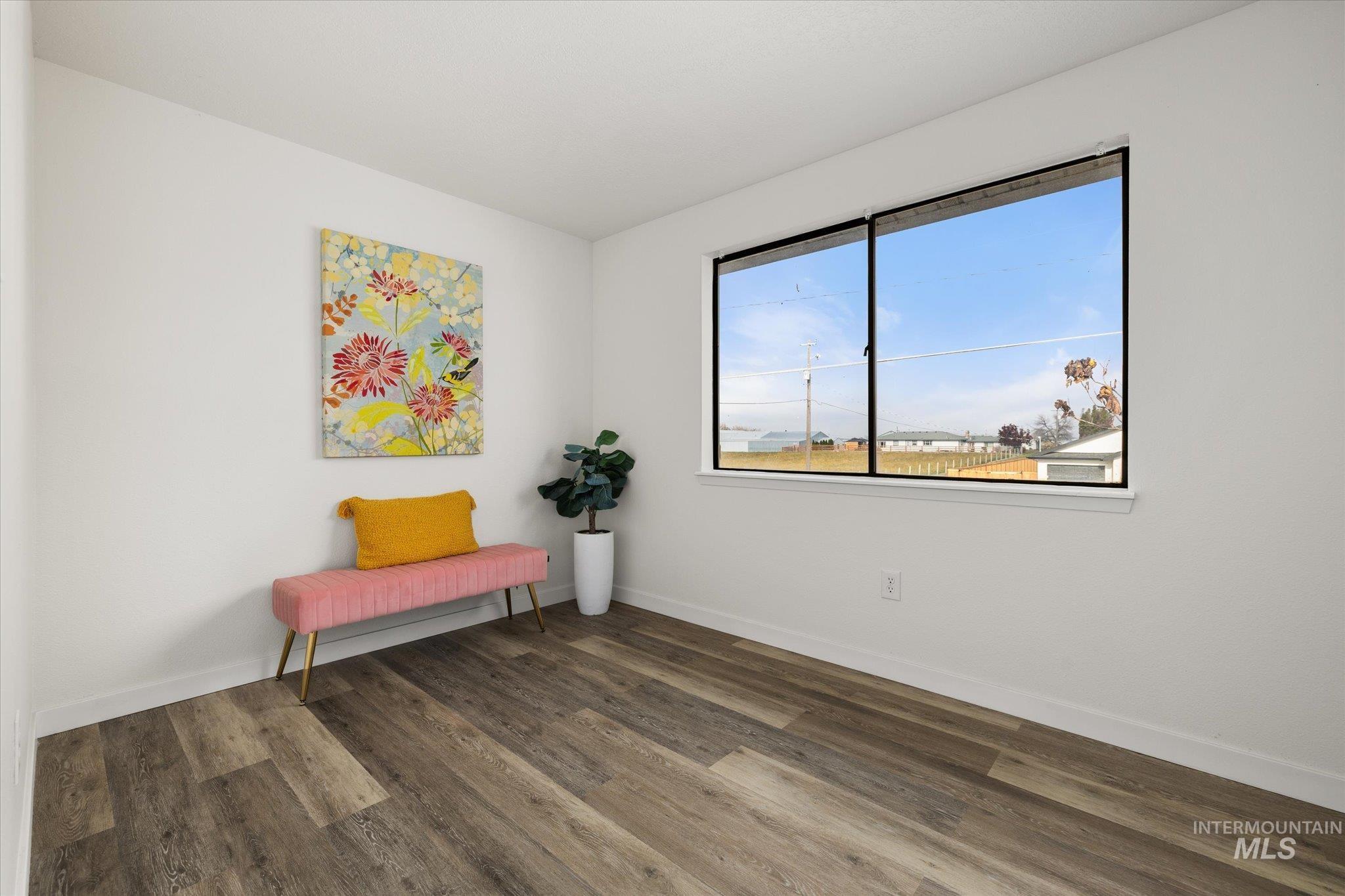 Living area featuring dark wood finished floors and baseboards