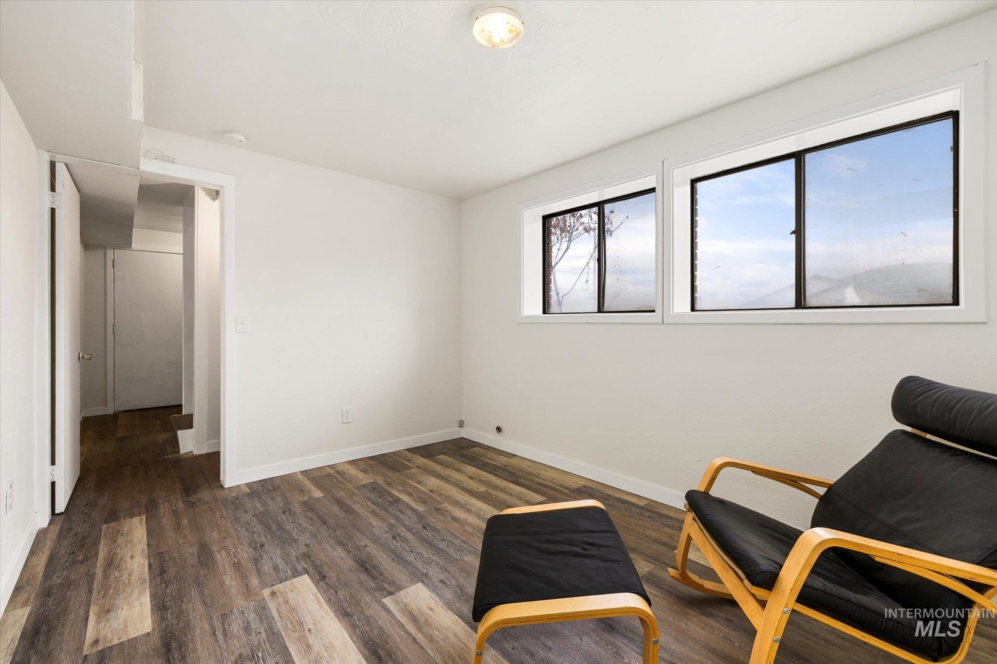 Sitting room featuring dark wood finished floors and baseboards