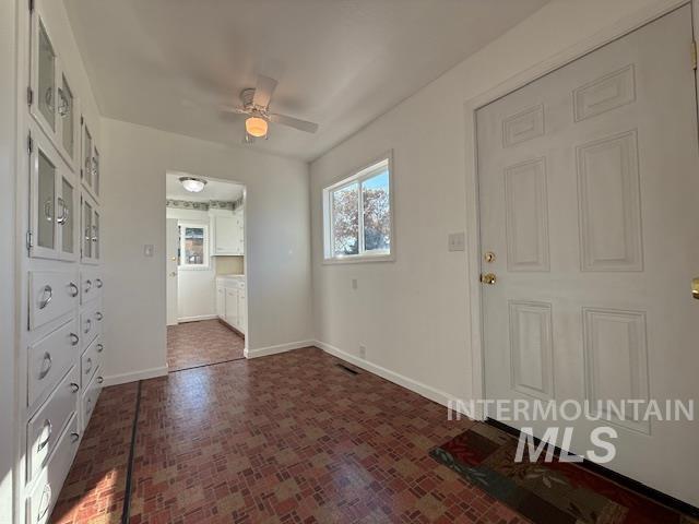 Foyer entrance featuring baseboards and ceiling fan