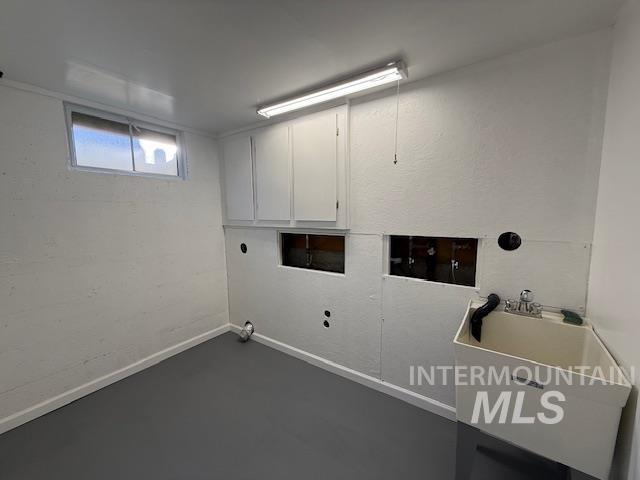 Laundry room with washer hookup, finished concrete flooring, and cabinet space