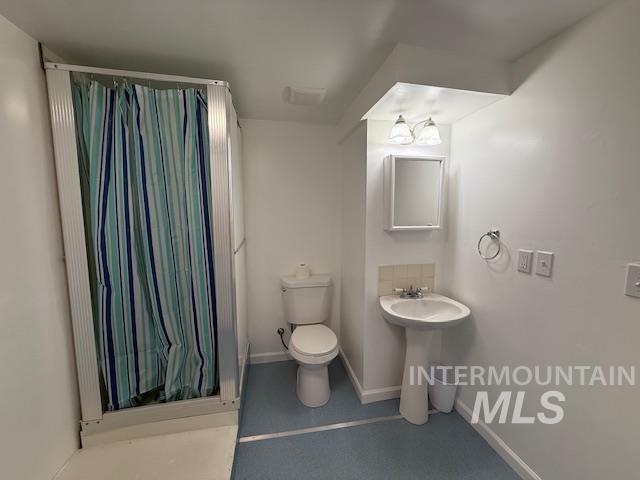Full bath featuring a shower stall and toilet