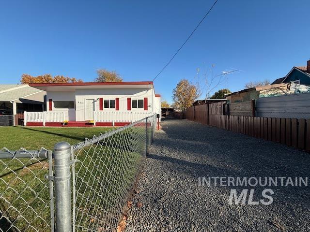 View of side of property featuring a fenced front yard and a gate