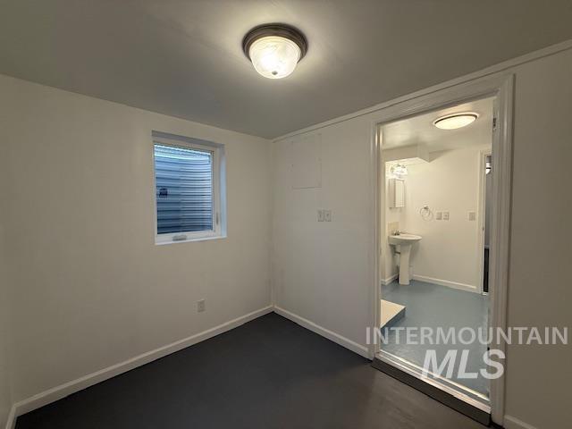 Unfurnished bedroom with baseboards and concrete floors