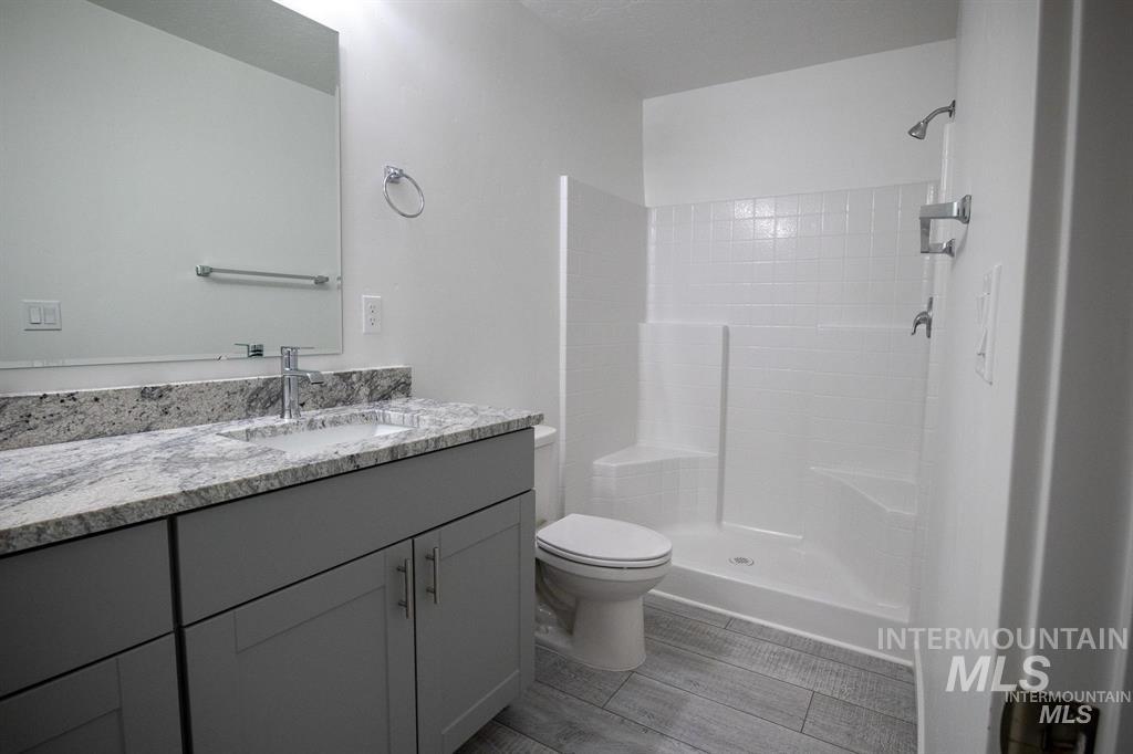 Bathroom featuring vanity, a shower stall, and light wood finished floors