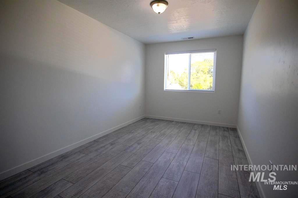 Unfurnished room featuring baseboards and light wood-type flooring