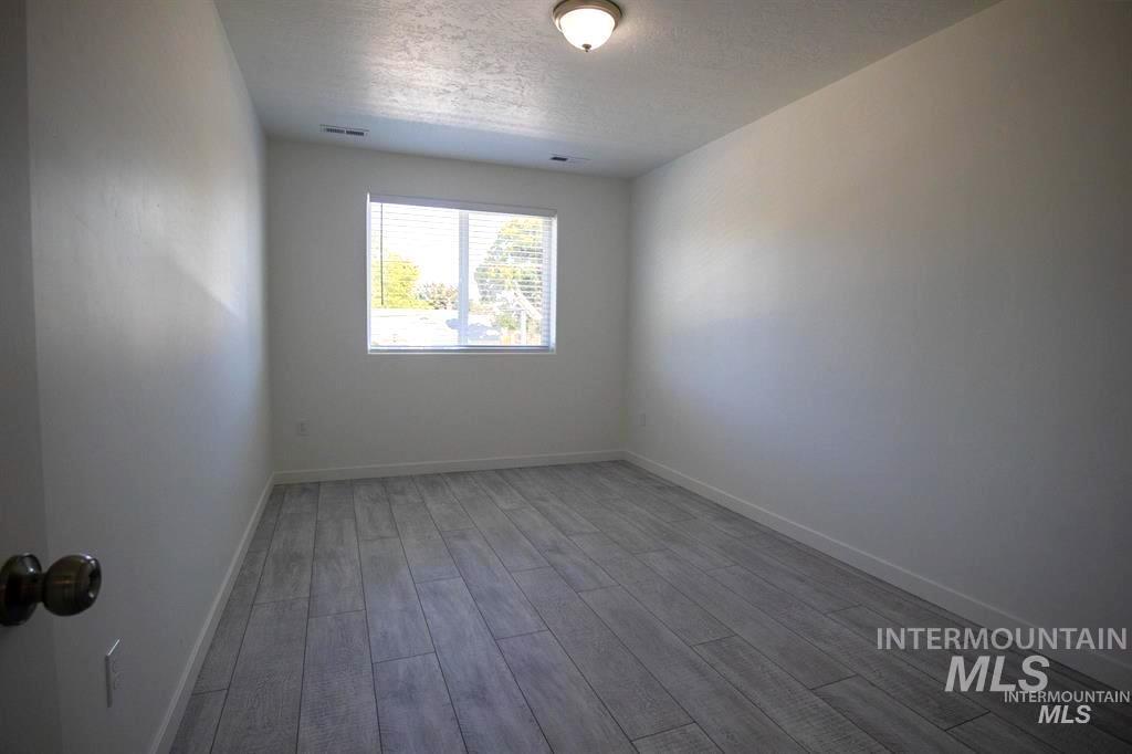 Unfurnished room featuring light wood finished floors and a textured ceiling