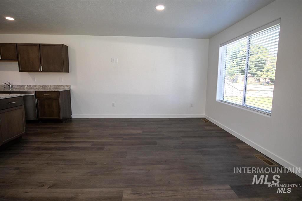 Kitchen featuring dark brown cabinetry, dark wood-type flooring, and recessed lighting