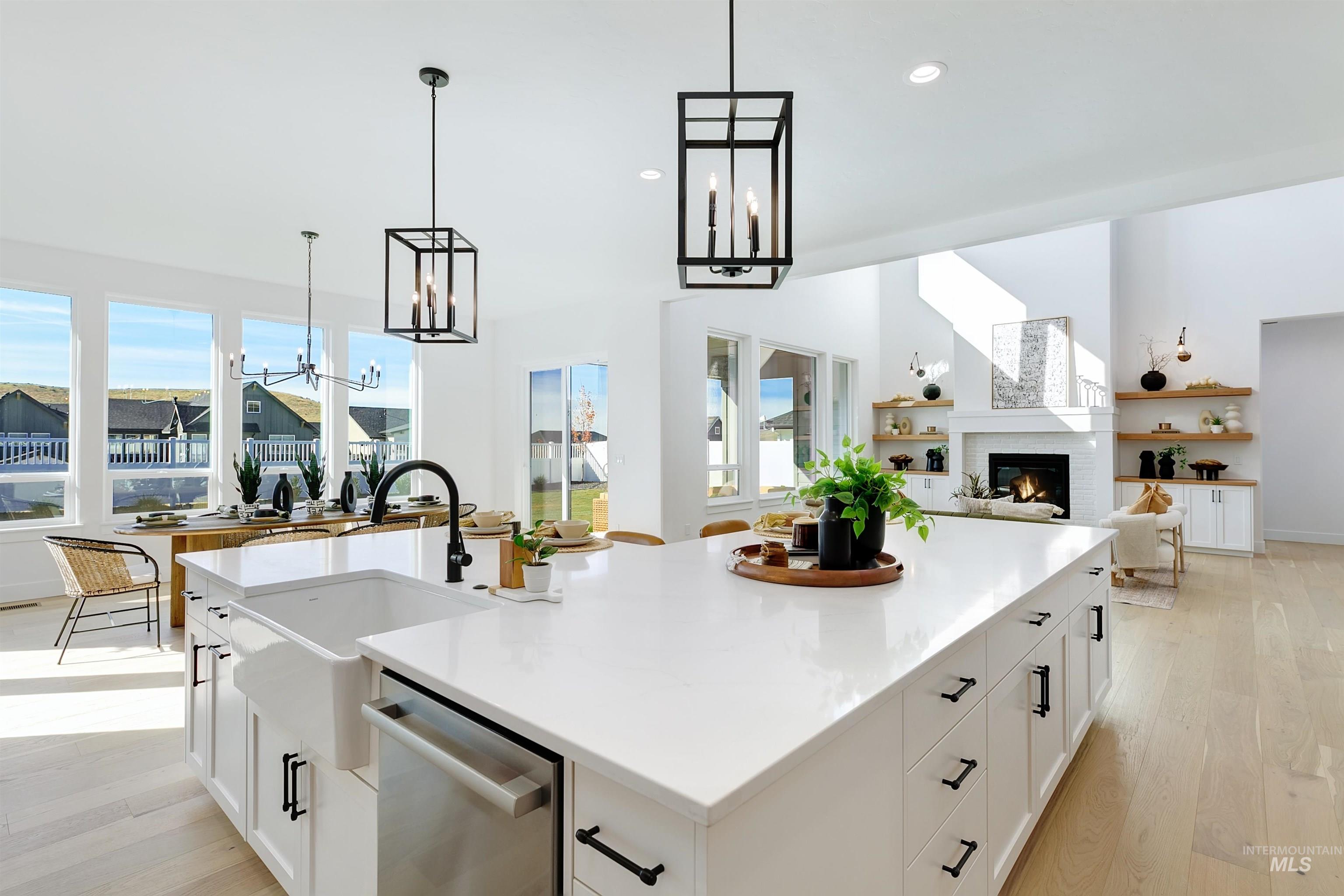 Kitchen featuring white cabinets, hanging light fixtures, light wood finished floors, open floor plan, and recessed lighting