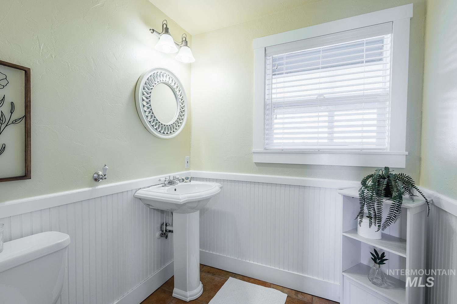 Bathroom with a wainscoted wall and toilet