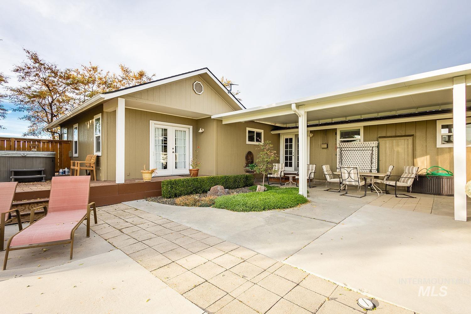 Rear view of property with a patio area, french doors, a hot tub, and outdoor dining space