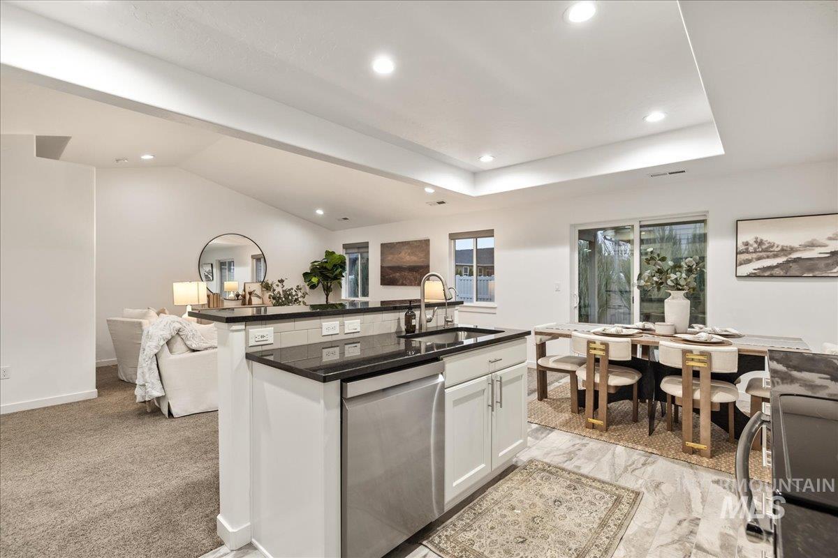 Kitchen featuring white cabinetry, open floor plan, appliances with stainless steel finishes, recessed lighting, and an island with sink