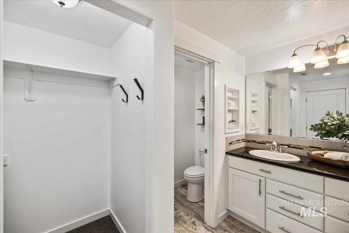 Full bath featuring vanity, a textured ceiling, and light wood-type flooring