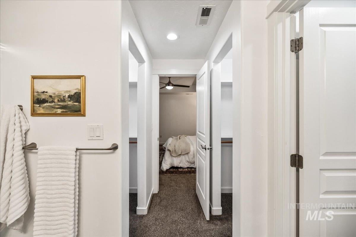 Corridor with dark colored carpet and recessed lighting