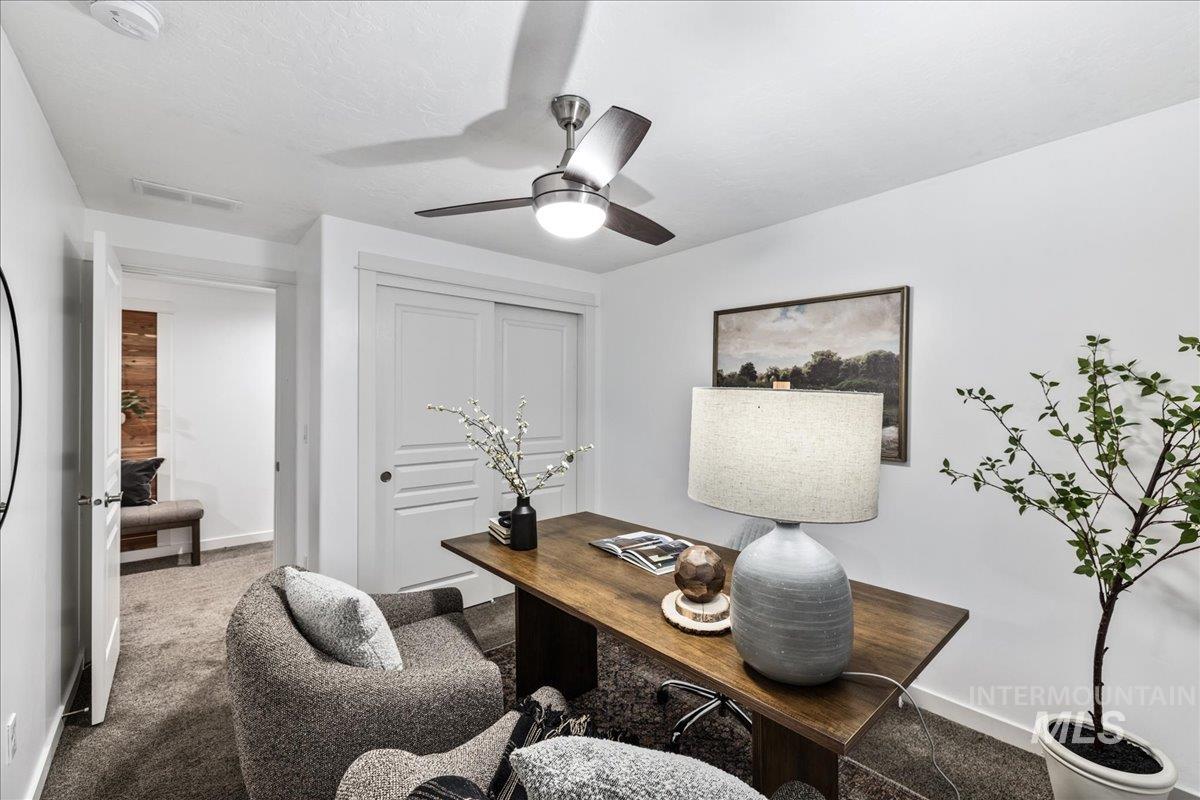 Office area with carpet and ceiling fan