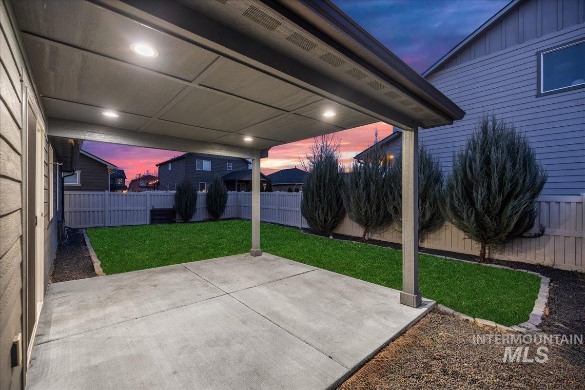 Patio terrace at dusk featuring a patio area and a fenced backyard