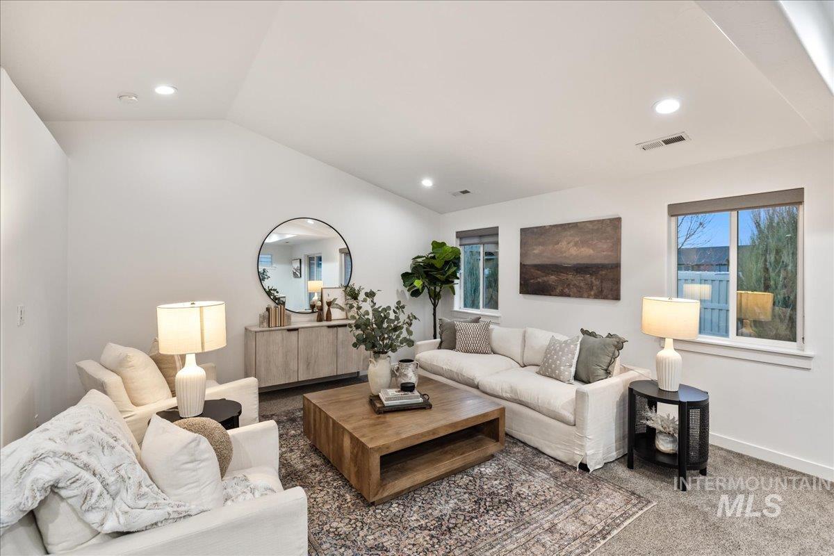 Living area with vaulted ceiling, carpet, and recessed lighting