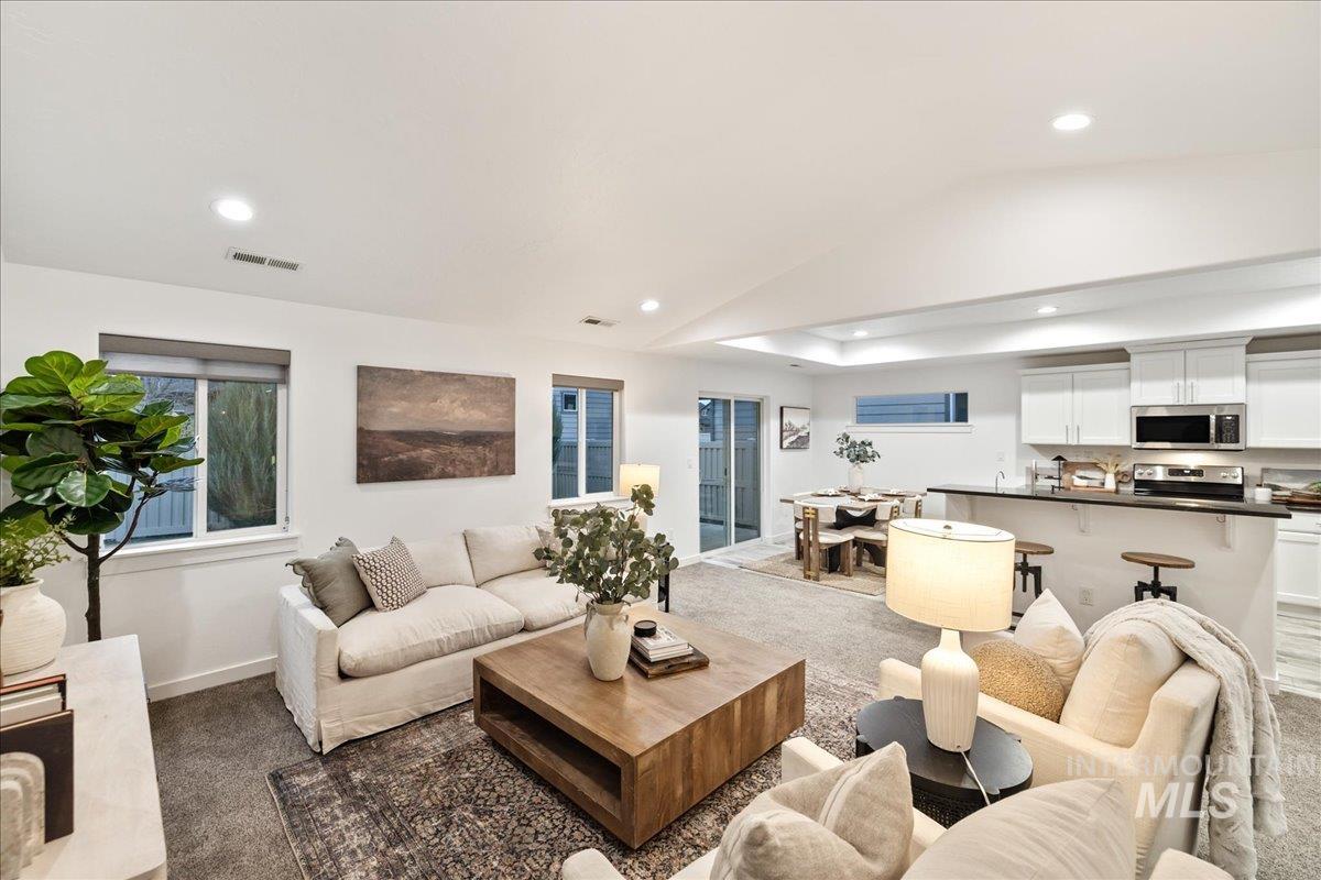 Carpeted living room featuring recessed lighting and lofted ceiling
