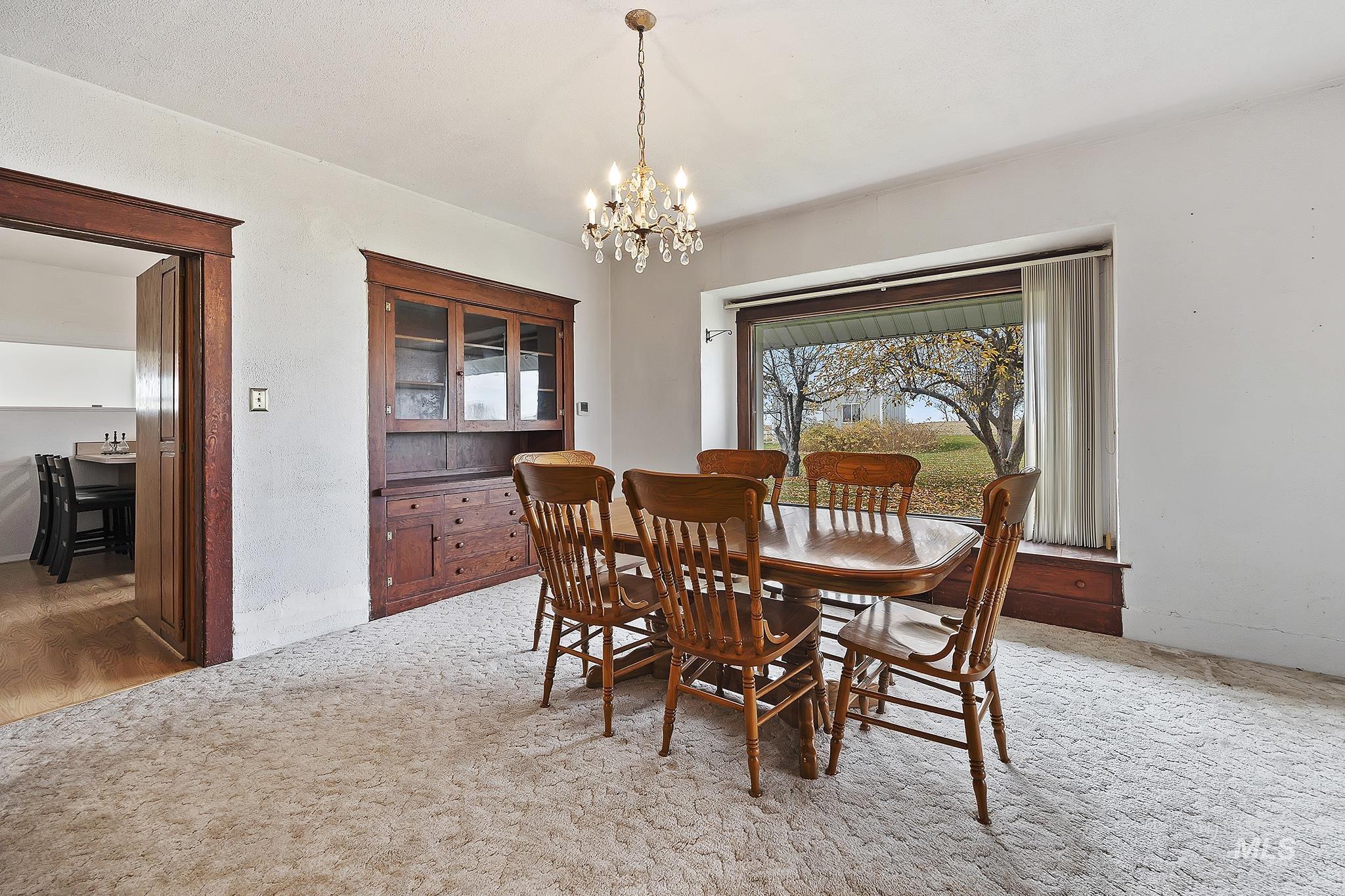 Dining space with a chandelier and light colored carpet