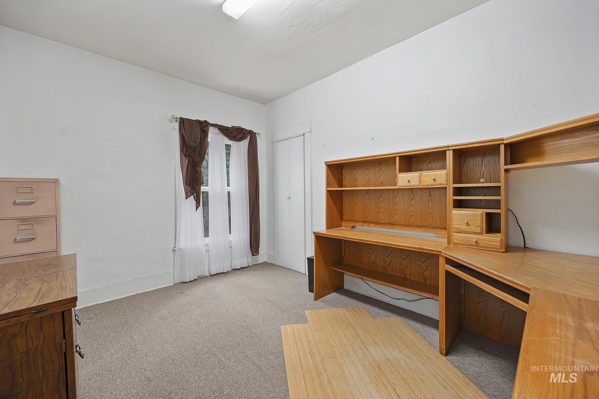 Unfurnished office with light colored carpet and baseboards