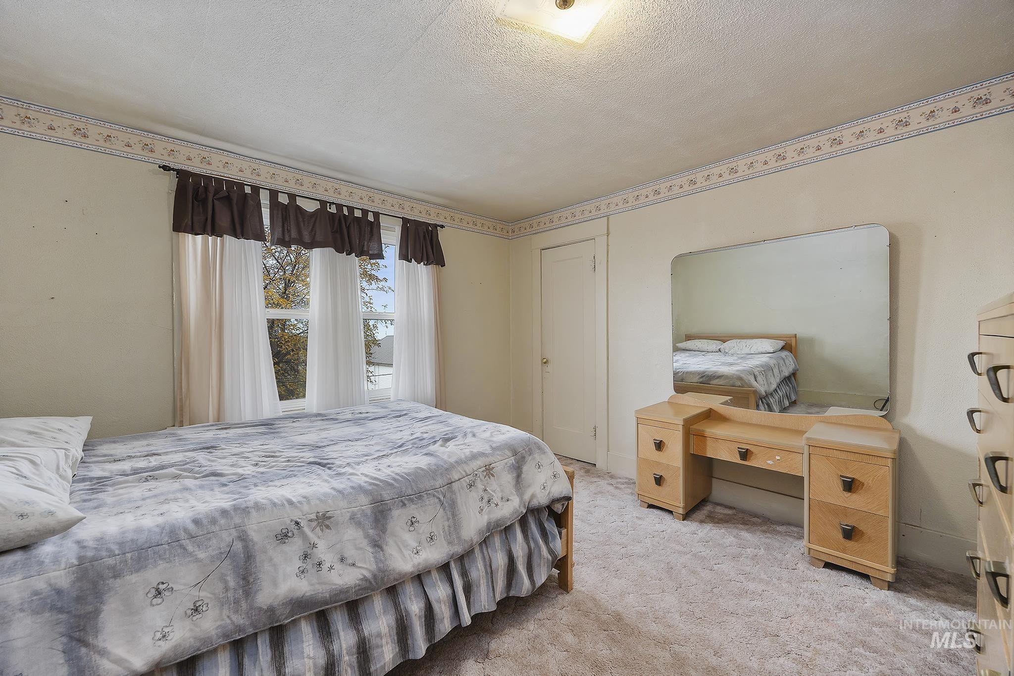 Bedroom featuring carpet flooring and a textured ceiling