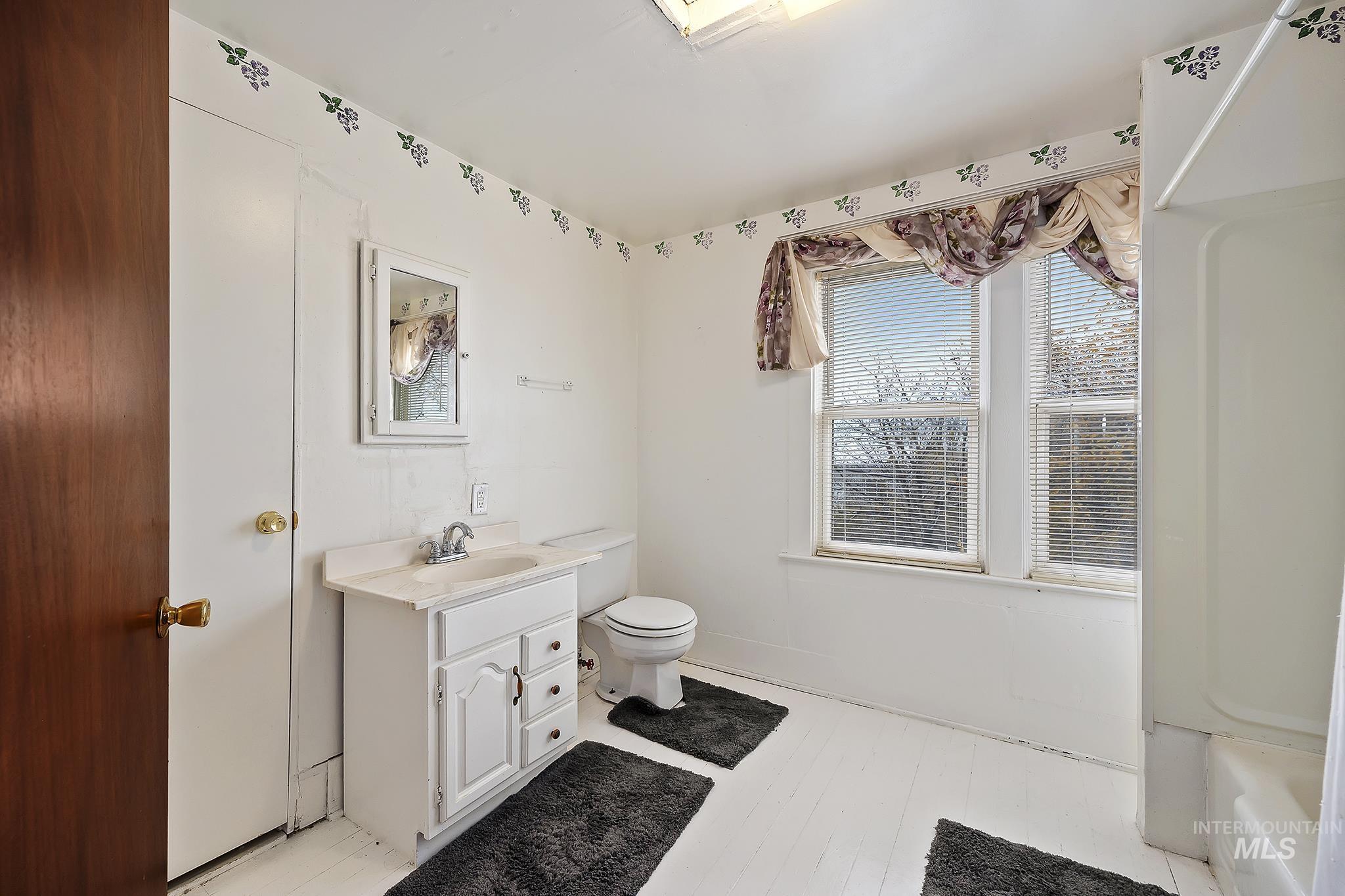 Full bath with vanity and light wood-style floors