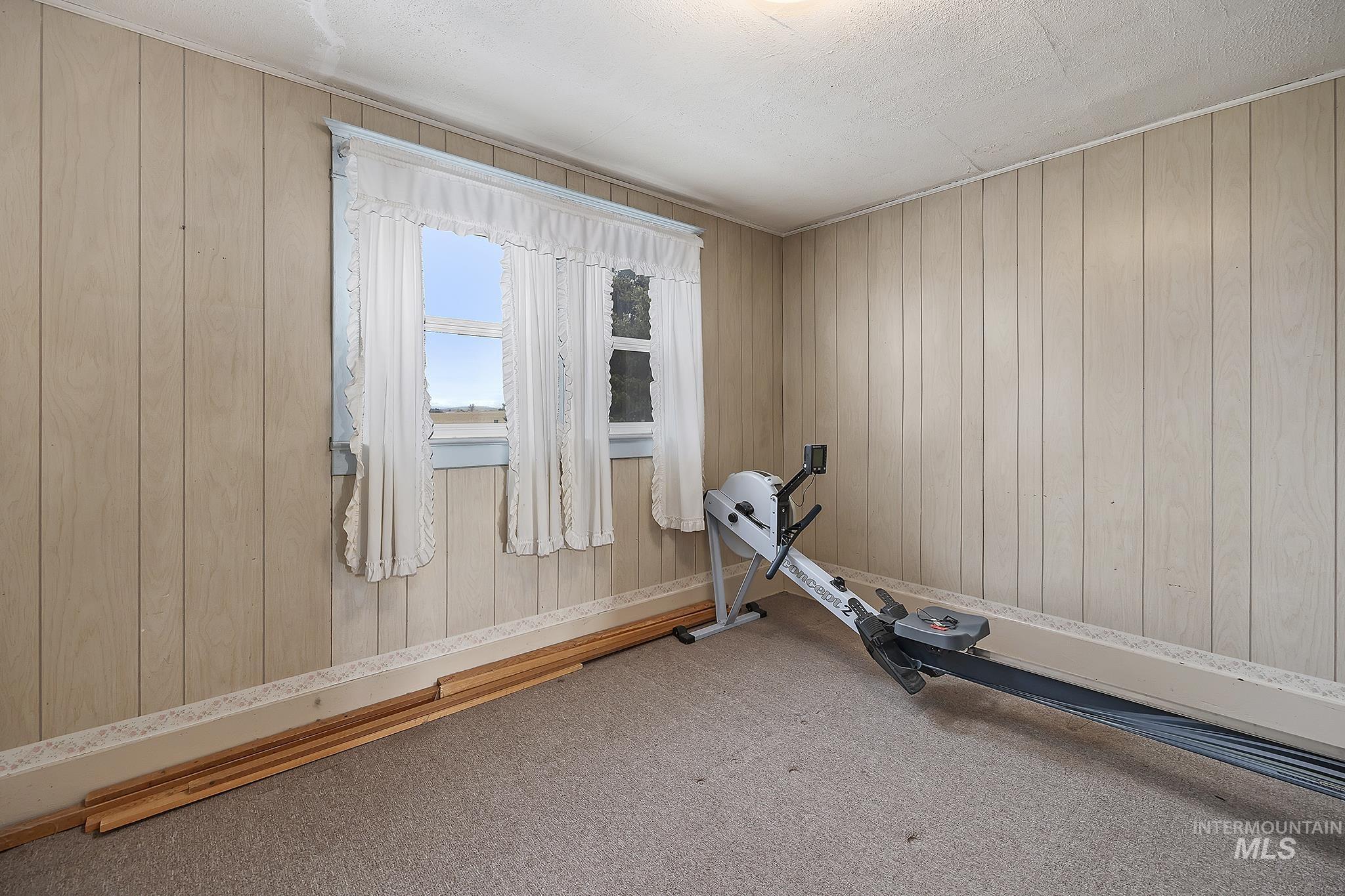 Workout area with carpet and wooden walls