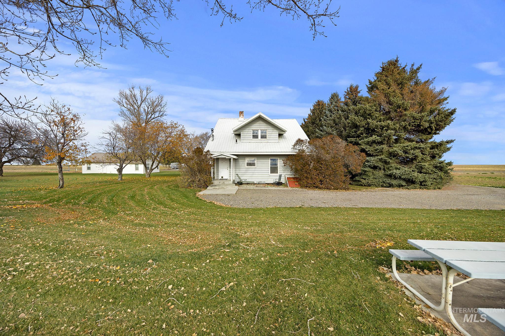 View of side of property with a chimney, a lawn, and a metal roof