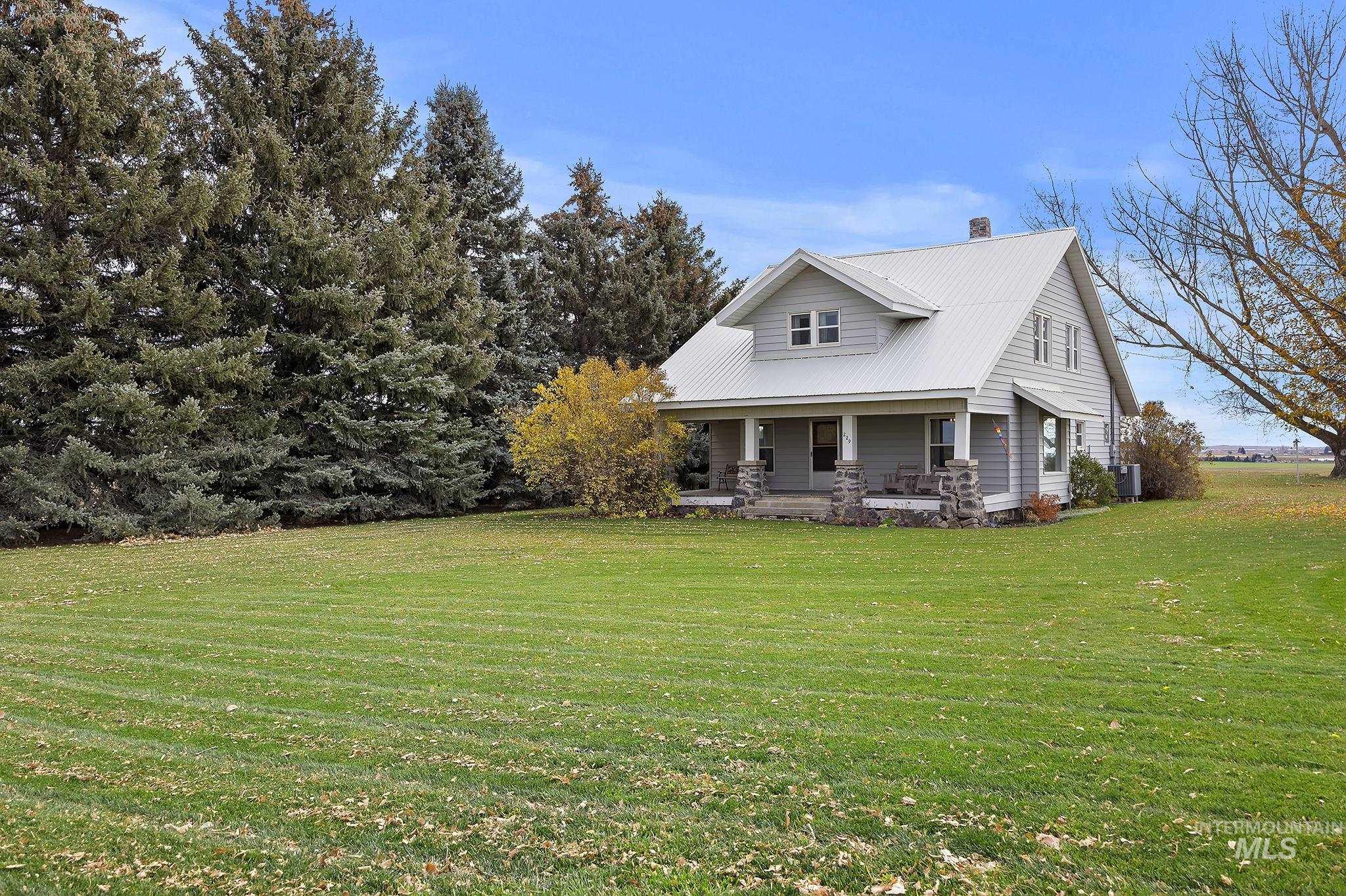 Back of house featuring a yard, a porch, a metal roof, and a chimney