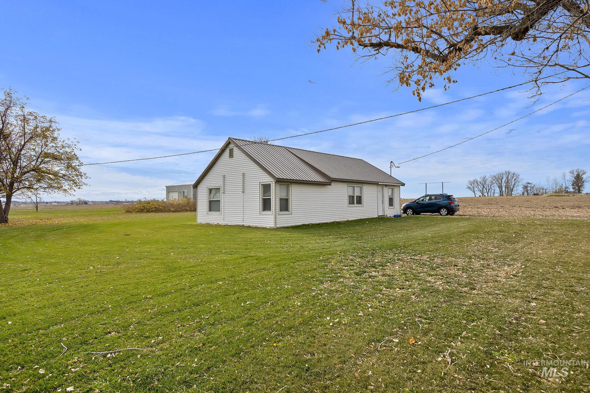 View of side of home with a yard and a metal roof