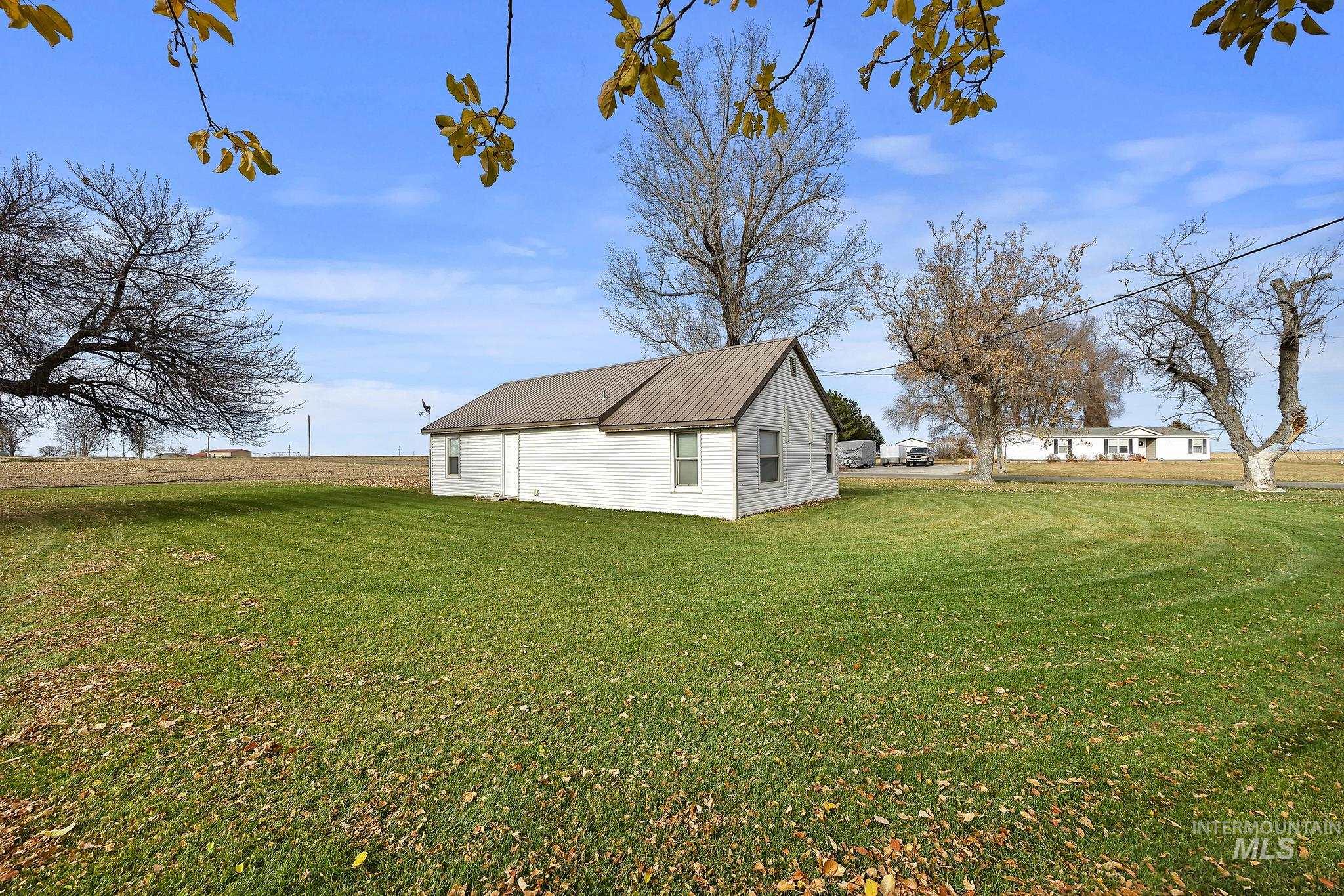 View of side of property with a yard and a metal roof