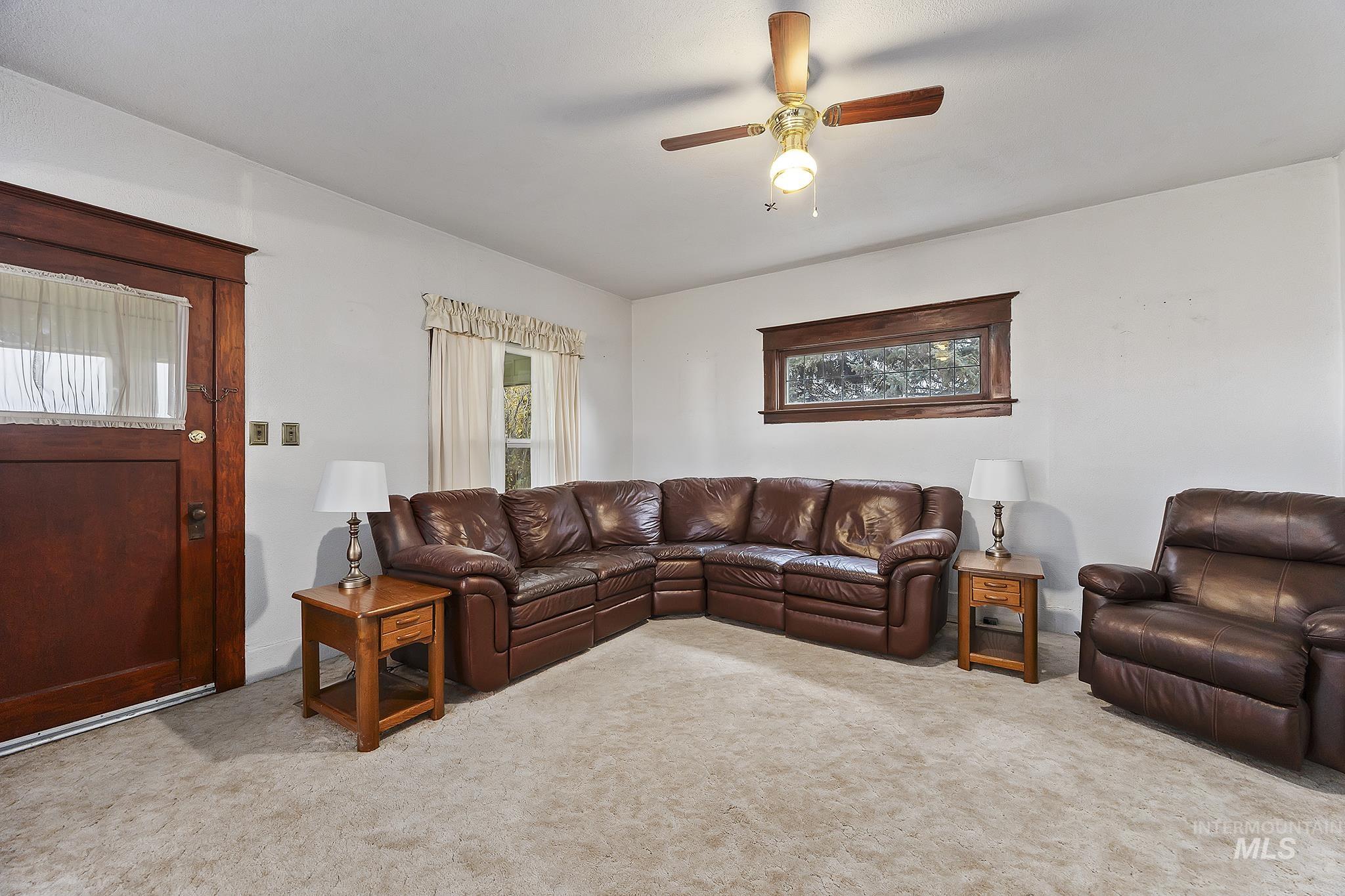 Living room with light colored carpet and ceiling fan