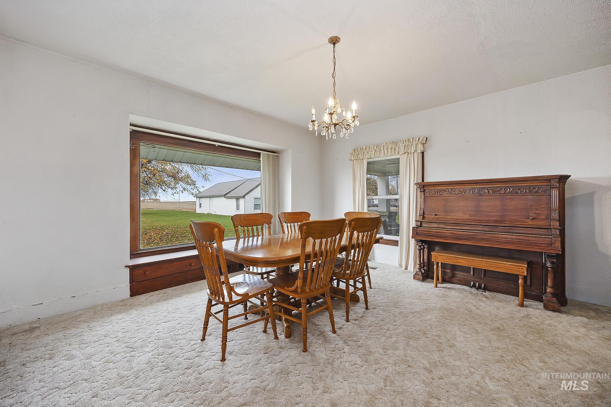 Dining space featuring light colored carpet and a chandelier