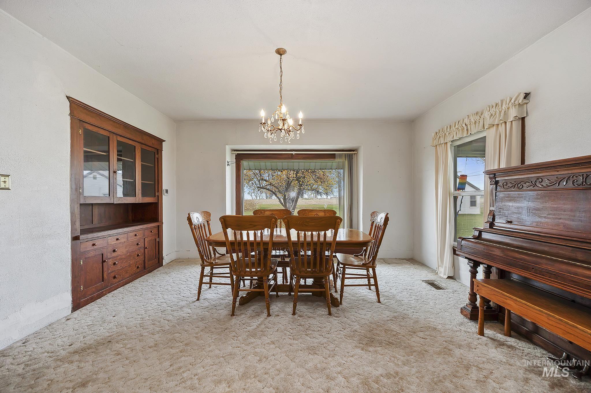 Dining area with light colored carpet and a chandelier