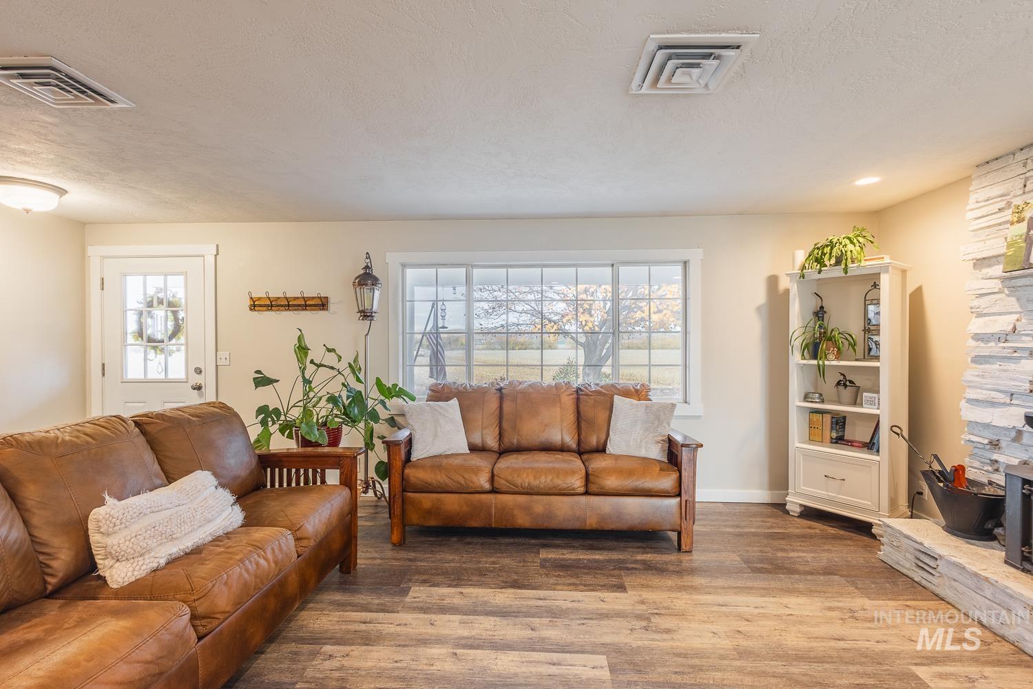 Living room featuring a textured ceiling, wood finished floors, and a fireplace